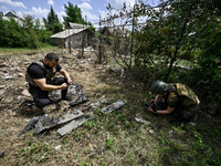 Police officers are recording damage next to a house that is partially destroyed by a Russian drone attack in Orikhiv, Zaporizhzhia region,...