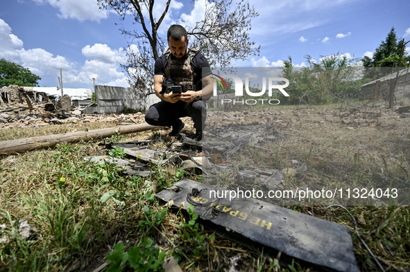 A police officer is recording damage next to a house that is partially destroyed by a Russian drone attack in Orikhiv, Zaporizhzhia region,...