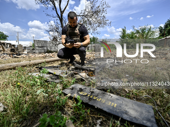 A police officer is recording damage next to a house that is partially destroyed by a Russian drone attack in Orikhiv, Zaporizhzhia region,...