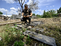 A police officer is recording damage next to a house that is partially destroyed by a Russian drone attack in Orikhiv, Zaporizhzhia region,...