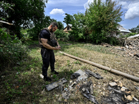 A police officer is recording damage next to a house that is partially destroyed by a Russian drone attack in Orikhiv, Zaporizhzhia region,...