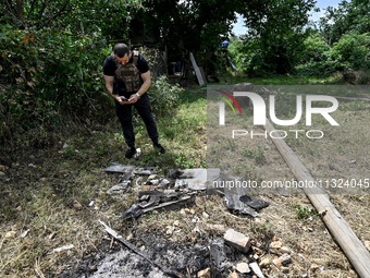 A police officer is recording damage next to a house that is partially destroyed by a Russian drone attack in Orikhiv, Zaporizhzhia region,...