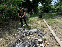 A police officer is recording damage next to a house that is partially destroyed by a Russian drone attack in Orikhiv, Zaporizhzhia region,...