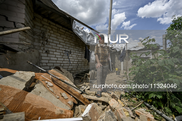 A woman is standing among the rubble at a house that is partially destroyed by a Russian drone attack in Orikhiv, Zaporizhzhia region, south...