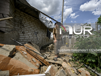 A woman is standing among the rubble at a house that is partially destroyed by a Russian drone attack in Orikhiv, Zaporizhzhia region, south...