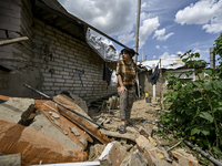 A woman is standing among the rubble at a house that is partially destroyed by a Russian drone attack in Orikhiv, Zaporizhzhia region, south...