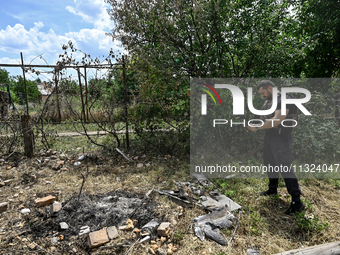 A police officer is recording damage next to a house that is partially destroyed by a Russian drone attack in Orikhiv, Zaporizhzhia region,...