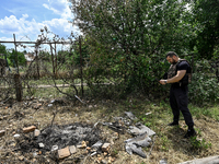 A police officer is recording damage next to a house that is partially destroyed by a Russian drone attack in Orikhiv, Zaporizhzhia region,...