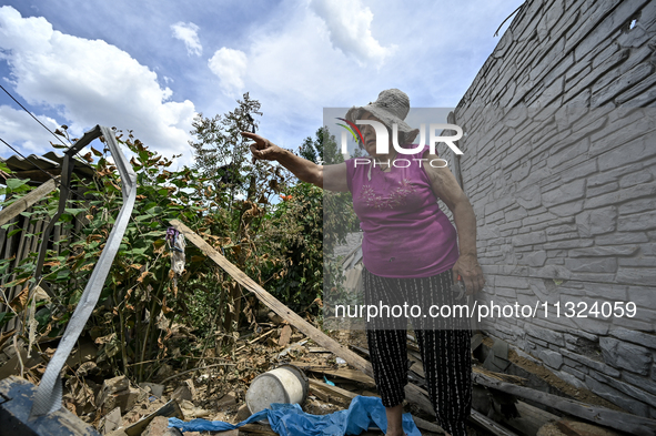 An elderly woman is standing among the rubble at a house that was partially destroyed by a Russian drone attack in Orikhiv, Zaporizhzhia reg...