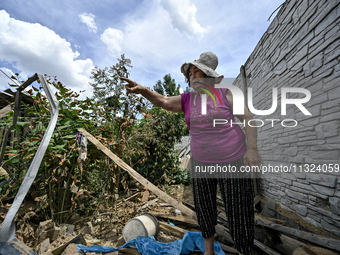 An elderly woman is standing among the rubble at a house that was partially destroyed by a Russian drone attack in Orikhiv, Zaporizhzhia reg...