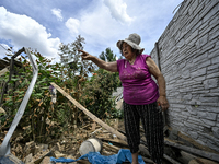 An elderly woman is standing among the rubble at a house that was partially destroyed by a Russian drone attack in Orikhiv, Zaporizhzhia reg...