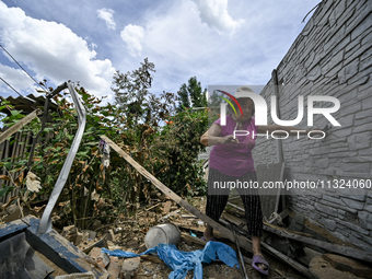 An elderly woman is walking through the rubble at a house that is partially destroyed by a Russian drone attack in Orikhiv, Zaporizhzhia reg...