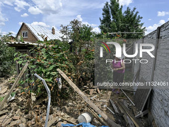 An elderly woman is walking through the rubble at a house that is partially destroyed by a Russian drone attack in Orikhiv, Zaporizhzhia reg...