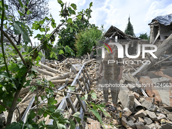 An elderly woman is standing among the rubble at a house that was partially destroyed by a Russian drone attack in Orikhiv, Zaporizhzhia reg...