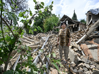 An elderly woman is standing among the rubble at a house that was partially destroyed by a Russian drone attack in Orikhiv, Zaporizhzhia reg...