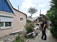 A police officer is recording damage next to a house that is partially destroyed by a Russian drone attack in Orikhiv, Zaporizhzhia region,...