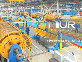 A worker is producing special cable products in Huzhou, China, on June 12, 2024. (