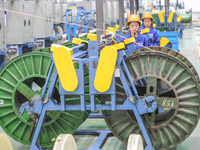 A worker is producing special cable products in Huzhou, China, on June 12, 2024. (