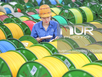 A worker is producing special cable products in Huzhou, China, on June 12, 2024. (