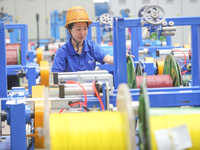 A worker is producing special cable products in Huzhou, China, on June 12, 2024. (