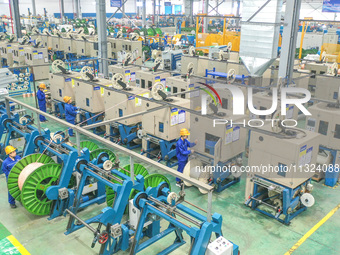 A worker is producing special cable products in Huzhou, China, on June 12, 2024. (