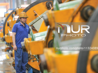 A worker is producing special cable products in Huzhou, China, on June 12, 2024. (