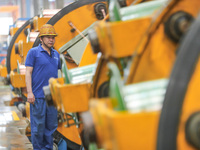 A worker is producing special cable products in Huzhou, China, on June 12, 2024. (