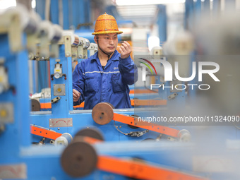 A worker is producing special cable products in Huzhou, China, on June 12, 2024. (