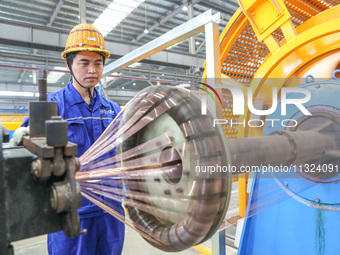 A worker is producing special cable products in Huzhou, China, on June 12, 2024. (