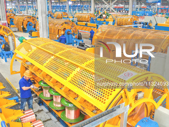 A worker is producing special cable products in Huzhou, China, on June 12, 2024. (