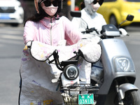 Citizens are wearing sun-protective clothing and riding on a street under high temperatures in Fuyang, China, on June 12, 2024. The Central...