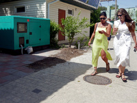 Two women are walking past a generator powering a cafe at the seaside during rolling blackouts in Odesa, Ukraine, on June 11, 2024. NO USE R...