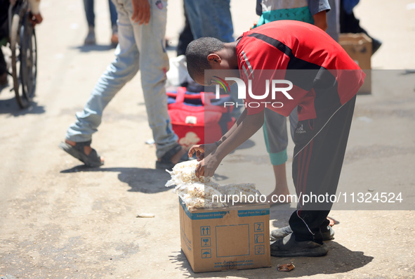 A displaced boy is selling popcorn and waiting for customers on a street next to Al-Aqsa Martyrs Hospital in Deir el-Balah, in the central G...