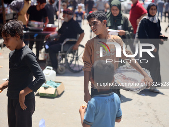 A displaced boy is selling sweets and waiting for customers on a street next to Al-Aqsa Martyrs Hospital in Deir el-Balah, in the central Ga...