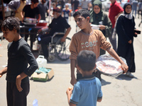 A displaced boy is selling sweets and waiting for customers on a street next to Al-Aqsa Martyrs Hospital in Deir el-Balah, in the central Ga...