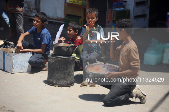 A displaced boy is selling lupin beans and waiting for customers on a street next to Al-Aqsa Martyrs Hospital in Deir el-Balah, in the centr...