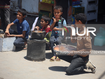 A displaced boy is selling lupin beans and waiting for customers on a street next to Al-Aqsa Martyrs Hospital in Deir el-Balah, in the centr...