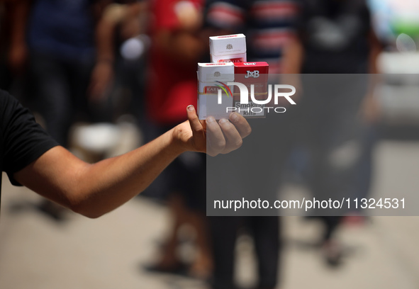 A displaced man is selling cigarettes on a street next to Al-Aqsa Martyrs Hospital in Deir el-Balah, in the central Gaza Strip, on June 12,...