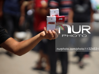 A displaced man is selling cigarettes on a street next to Al-Aqsa Martyrs Hospital in Deir el-Balah, in the central Gaza Strip, on June 12,...