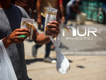 A displaced man is selling hand-rolled cigarettes on a street next to Al-Aqsa Martyrs Hospital in Deir el-Balah, in the central Gaza Strip,...