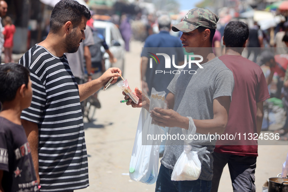 A displaced man is selling hand-rolled cigarettes on a street next to Al-Aqsa Martyrs Hospital in Deir el-Balah, in the central Gaza Strip,...