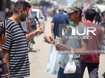 A displaced man is selling hand-rolled cigarettes on a street next to Al-Aqsa Martyrs Hospital in Deir el-Balah, in the central Gaza Strip,...