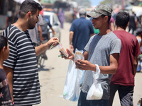 A displaced man is selling hand-rolled cigarettes on a street next to Al-Aqsa Martyrs Hospital in Deir el-Balah, in the central Gaza Strip,...