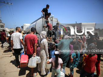 Palestinians are lining up to fill their containers with water on a street next to tents in Deir el-Balah, in the central Gaza Strip, on Jun...