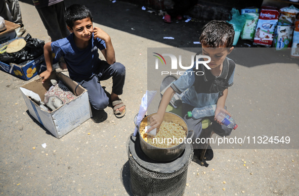 A displaced boy is selling lupin beans and waiting for customers on a street next to Al-Aqsa Martyrs Hospital in Deir el-Balah, in the centr...