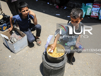 A displaced boy is selling lupin beans and waiting for customers on a street next to Al-Aqsa Martyrs Hospital in Deir el-Balah, in the centr...