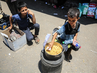 A displaced boy is selling lupin beans and waiting for customers on a street next to Al-Aqsa Martyrs Hospital in Deir el-Balah, in the centr...