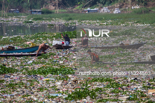 Residents on boats are collecting recyclable plastics from the heavily polluted Citarum River in Batujajar, Bandung, West Java, Indonesia, o...