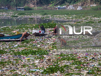 Residents on boats are collecting recyclable plastics from the heavily polluted Citarum River in Batujajar, Bandung, West Java, Indonesia, o...