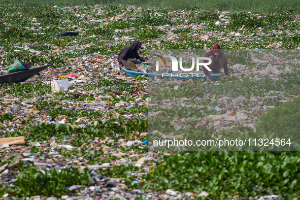 Residents on boats are collecting recyclable plastics from the heavily polluted Citarum River in Batujajar, Bandung, West Java, Indonesia, o...